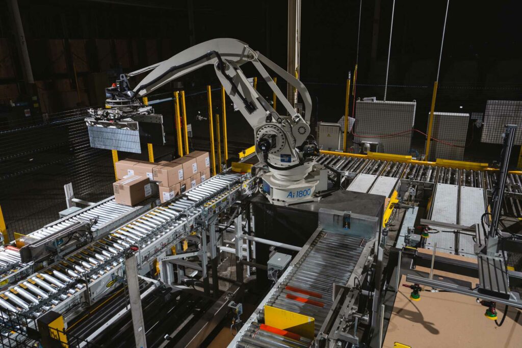 robot arm moving boxes in a manufacturing setting