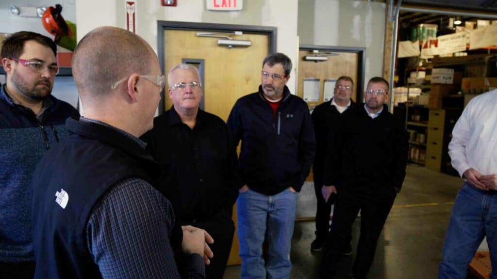 group of men standing in warehouse