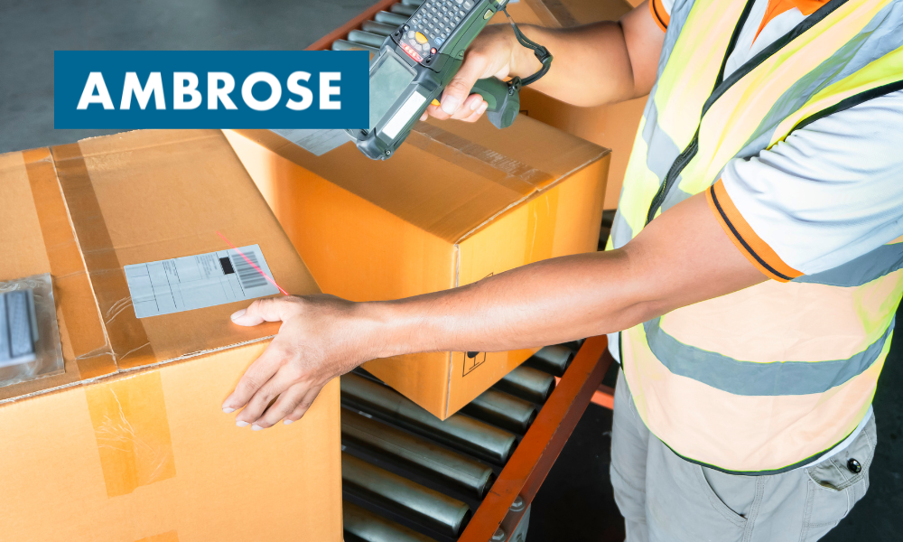 Man scanning package on a conveyor belt.