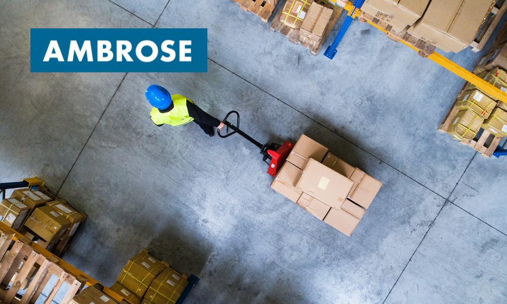 Man safely moving boxes in a warehouse.